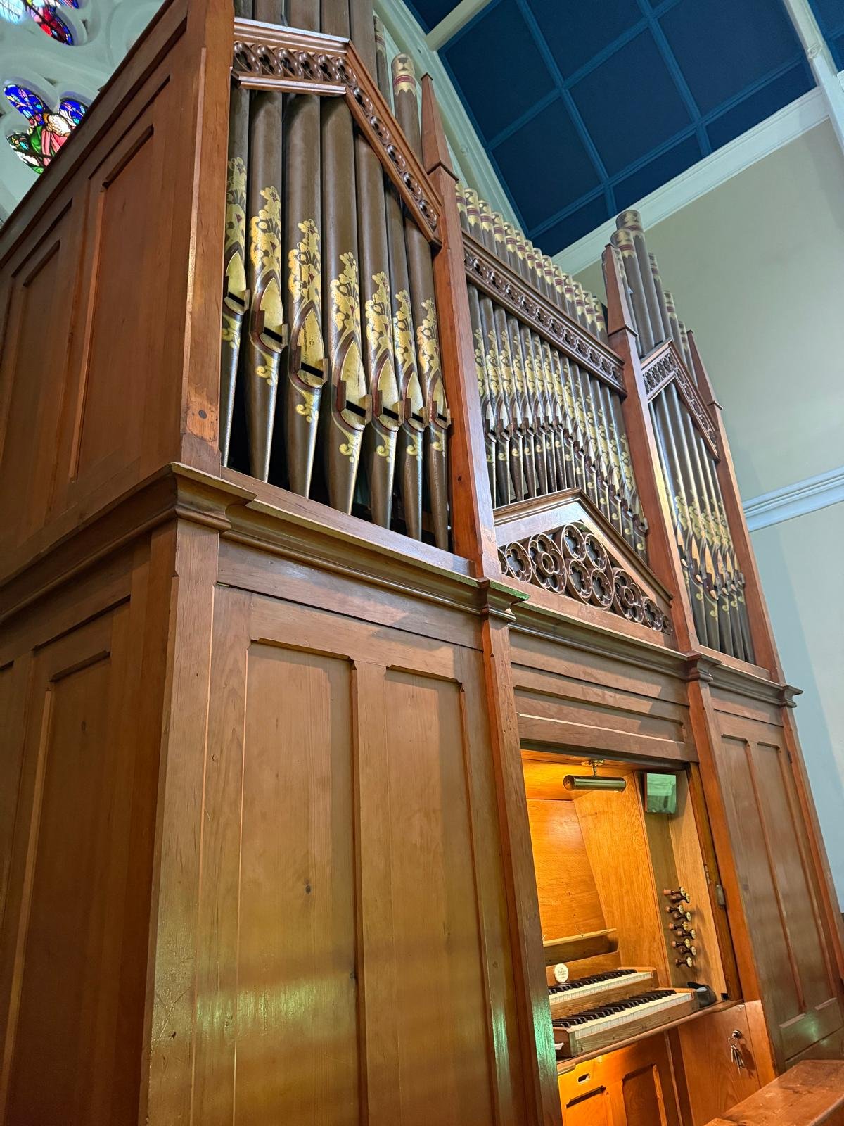 Ornate pipe organ case with golden pipes
